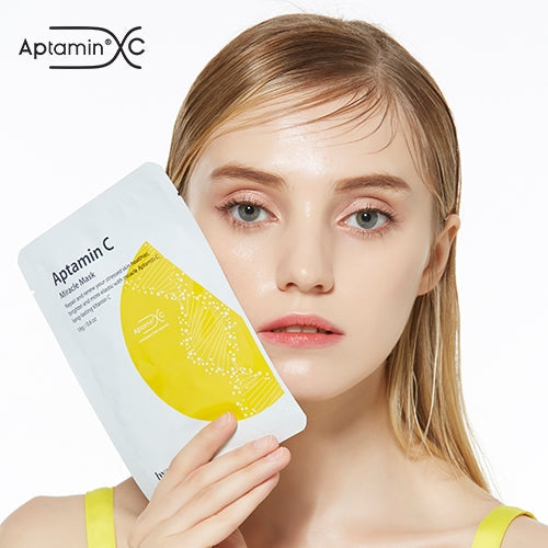Aptamin C Miracle Mask pack held by a woman, featuring patented technology for brightening and hydration.